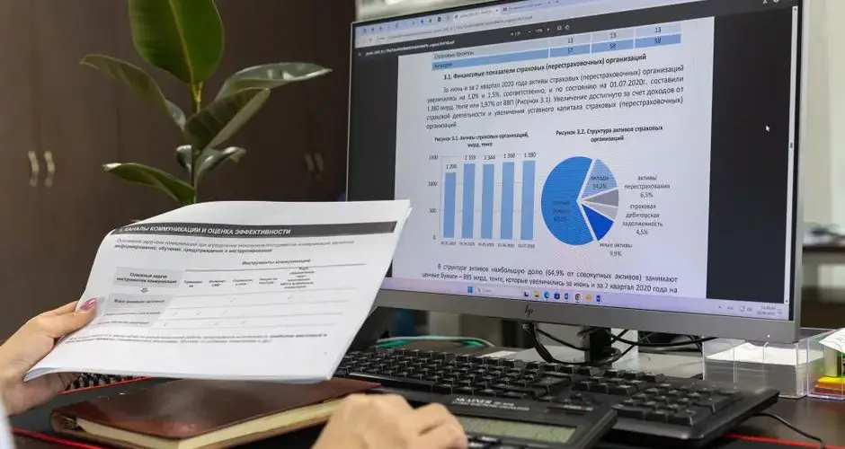 Person analyzing financial data on a computer screen in an office setting.