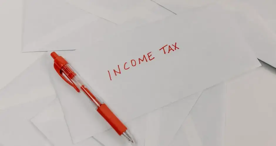 Studio shot of income tax envelope with red pen for accounting and tax season preparation.