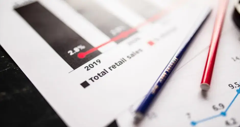 Detail view of retail sales chart and pencils on desk, showcasing data analysis.
