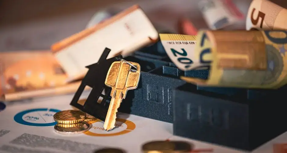 Close-up of house keys, euro bills, and charts symbolizing real estate investment and finance.