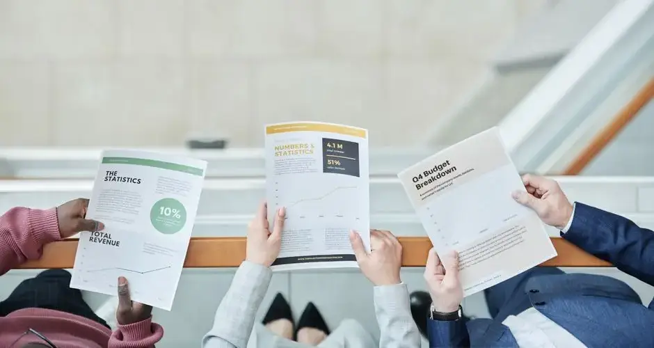 Group of business professionals analyzing financial documents in an office setting.