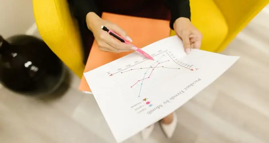 Woman reviewing a product trend graph analysis indoors.