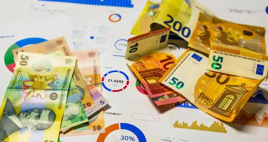 Colorful Euro and Romanian Lei banknotes on top of financial charts, symbolizing currency exchange and economic analysis.
