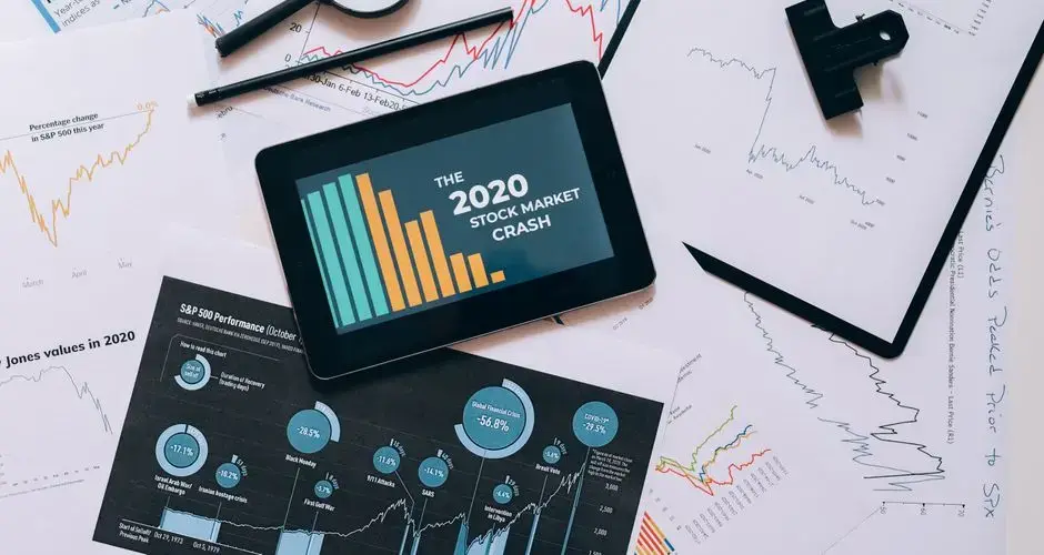 Tablet displaying 2020 stock market crash amidst graphs and charts. Perfect for financial analysis themes.