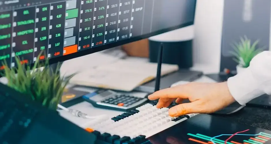 Professional workspace with trading charts and market data on screens, ideal for finance and investment contexts.