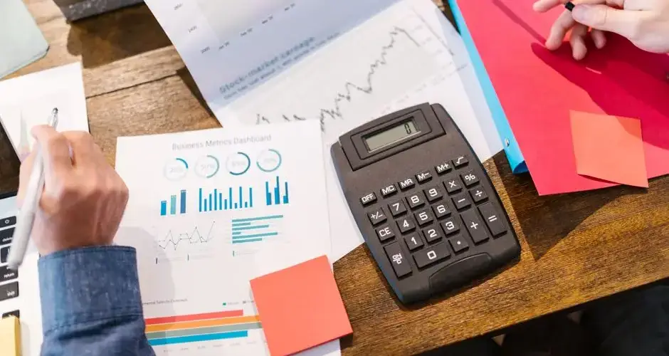 Financial analysis and planning tools with graphs and calculator on a table.