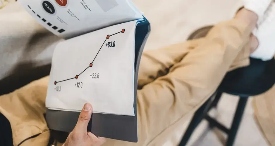 Close-up of a man reviewing business growth charts and statistics in an office setting.