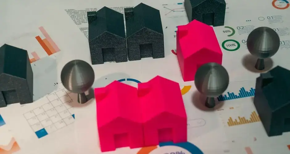 Abstract representation of real estate market analysis with model houses and charts.