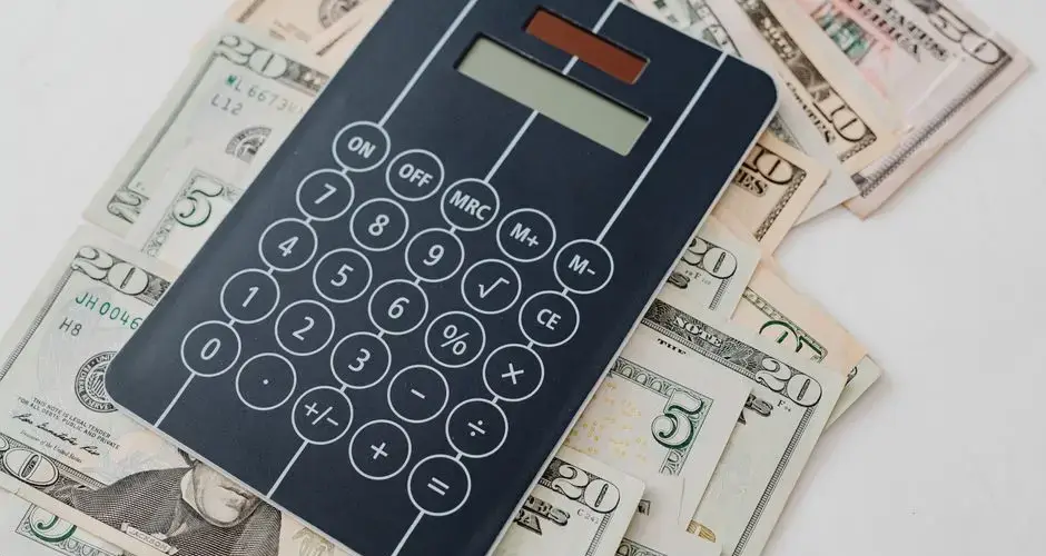 Close-up of a calculator atop US dollar bills, symbolizing financial planning and budgeting.