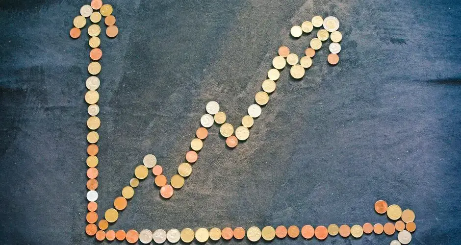 An upward trend graph made from coins representing financial growth and success.