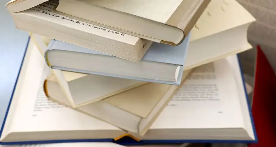 A disorganized stack of open and closed books showcasing education and study themes.