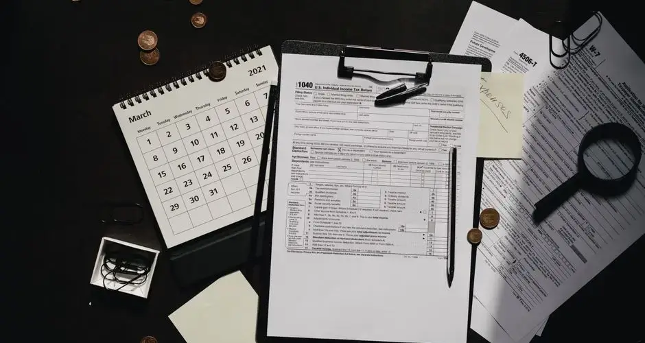 A neatly organized workspace featuring tax forms, calendar, magnifying glass, and office supplies for efficient tax preparation.