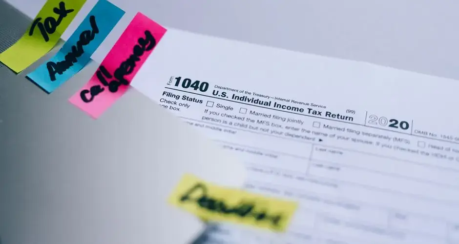 Close-up of 1040 U.S. tax form with colorful sticky notes for organization.