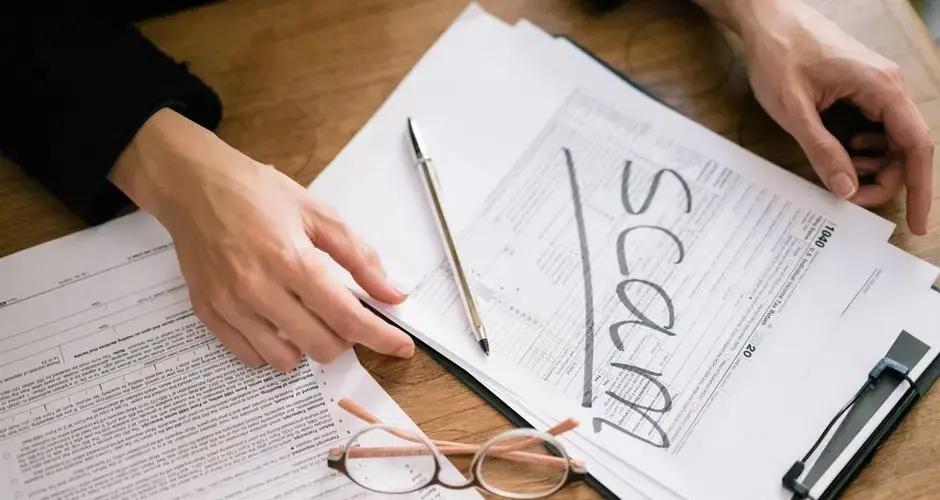 A close look at tax forms marked with scam, highlighting financial fraud risks.