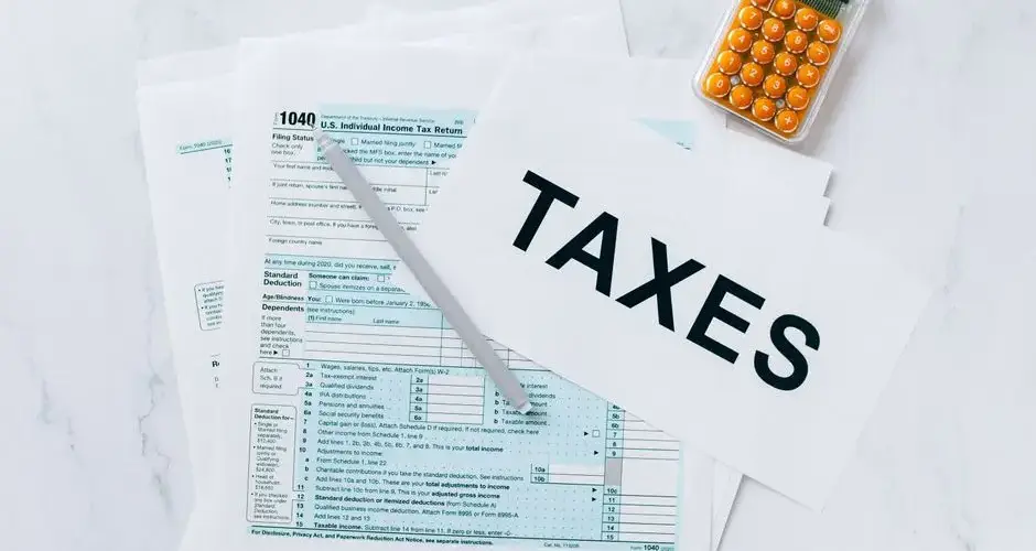 Top view of tax forms, a calculator, and pen for tax preparation.