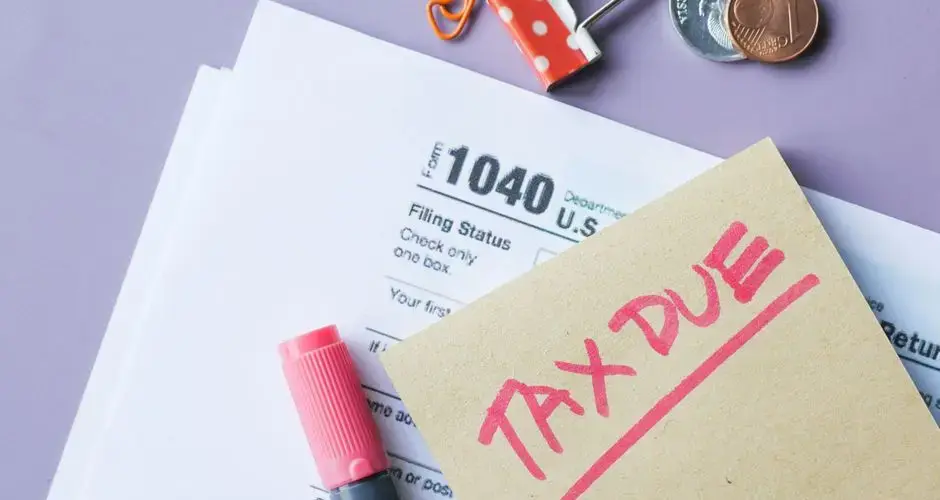 Close-up of IRS Form 1040 with 'Tax Due' note and stationery on a desk.