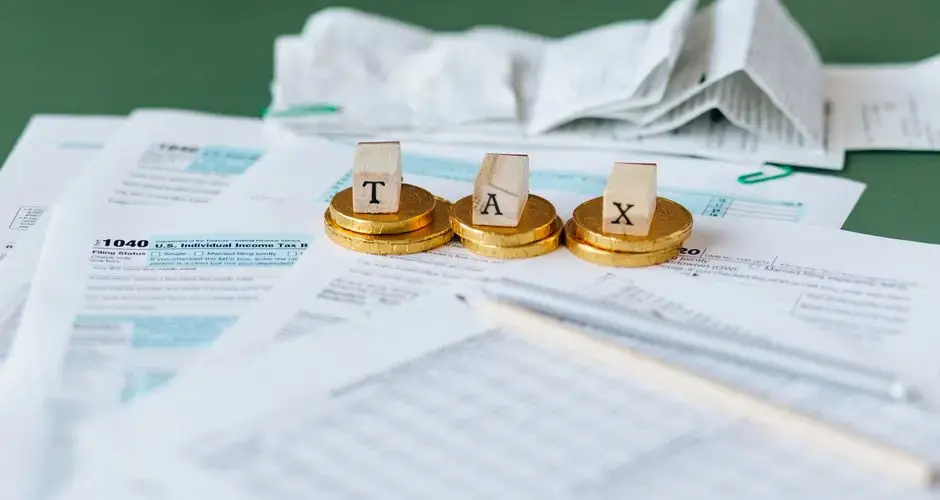 Close-up of tax forms, receipts, and coins symbolizing financial accounting and taxes.
