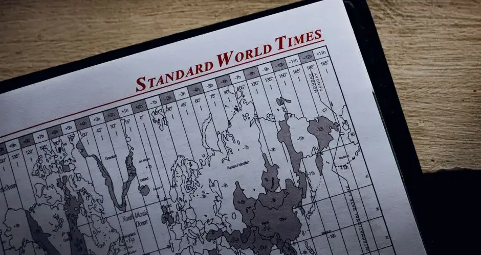 Top view of time zone illustration on page of agenda with inscription on wooden surface