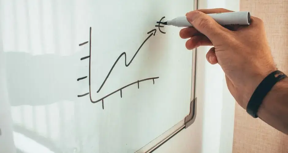 Crop faceless male financier drawing scheme on whiteboard with marker during creating new project