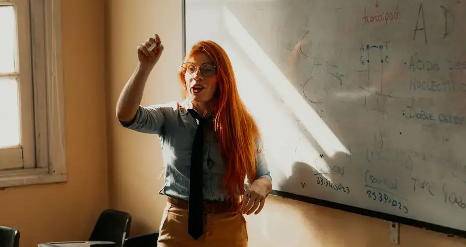 A teacher explaining a concept at a whiteboard. Bright classroom setting in Buenos Aires, Argentina.