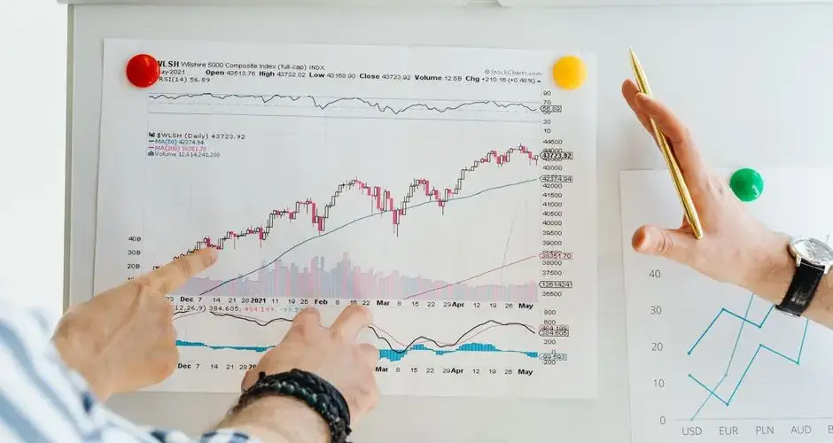 Two professionals analyze stock market graphs with a focus on finance and data trends.