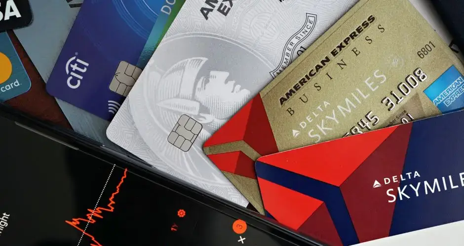 Image showing credit cards and a financial market graph on a smartphone.