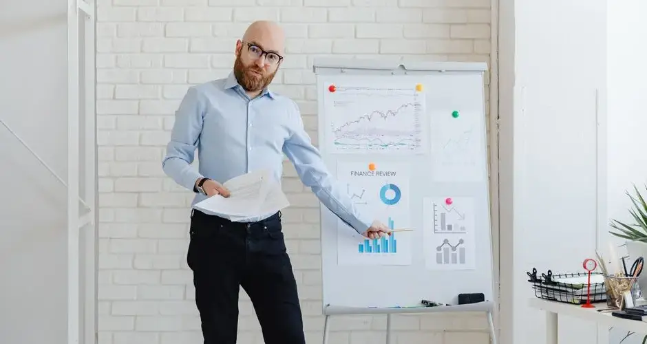 Businessman explaining charts and graphs during a financial presentation in modern office.