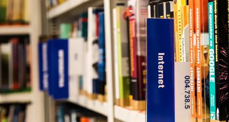 Close-up of a library shelf with books on internet and technology. Ideal for education-themed projects.