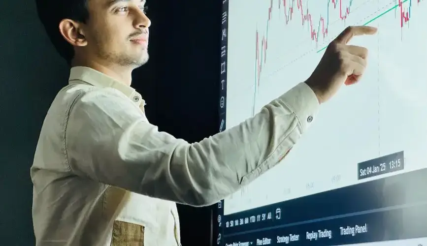 Man analyzing stock market graph on a digital board with a focused expression.