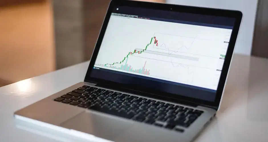 Close-up of a laptop showing a financial trading graph, ideal for finance and technology themes.