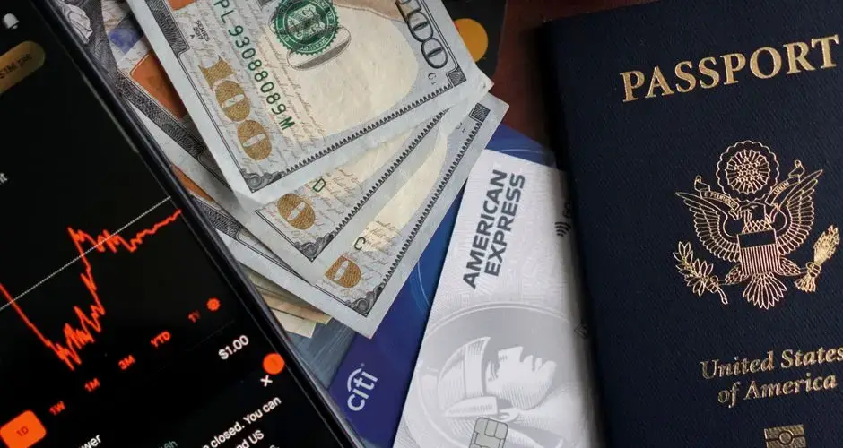 Stock trading concepts with passport, credit cards, cash, and smartphone app image.
