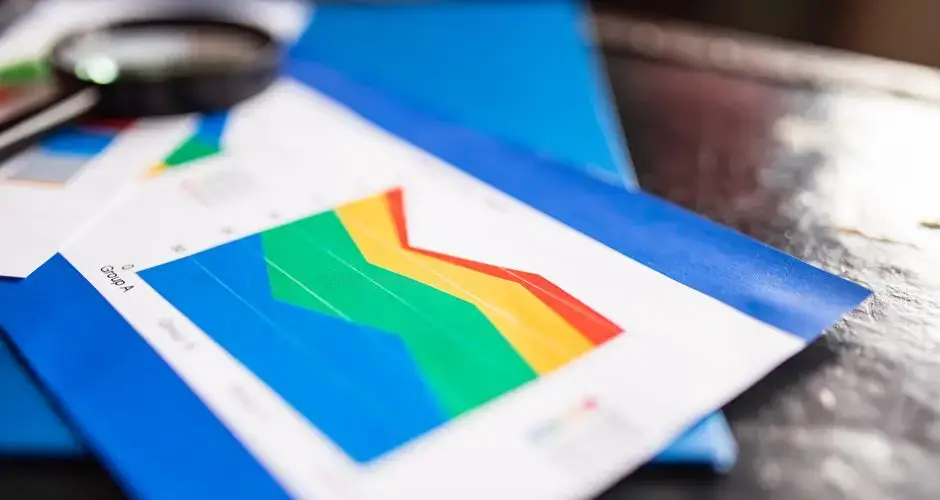 Close-up of a colorful business chart placed on a table with documents highlighting trends.