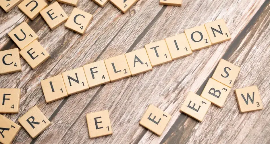 Wooden letter tiles forming the word 'inflation' on a rustic wooden surface, symbolizing economic themes.