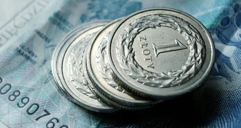 Close-up of Polish zloty coins stacked on a banknote. Financial concept.