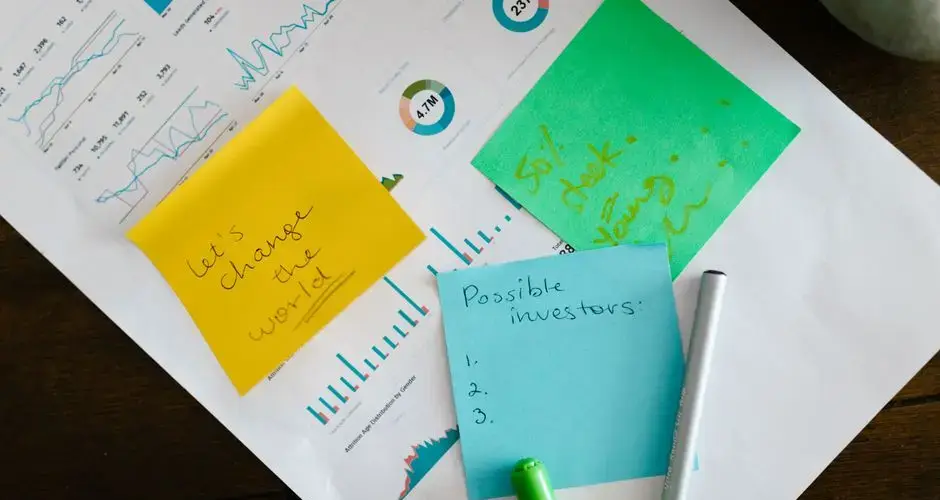 Startup brainstorming with charts, colorful sticky notes, and planning strategies for success.