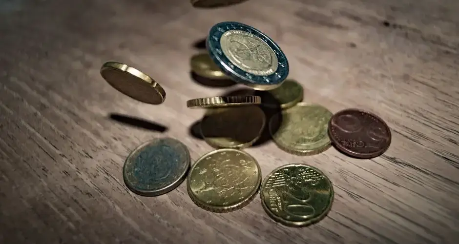 Capture of euro coins falling and spinning on a wooden table. Perfect depiction of finance and currency.