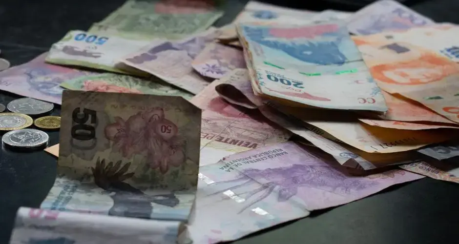 A mix of international banknotes and coins displayed on a table, highlighting diverse world currencies.