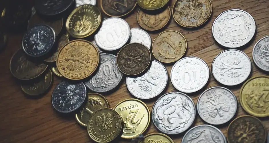 Close-up view of various Polish coins on a wooden table showcasing currency and finance concepts.