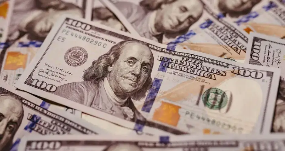 Pile of 100 dollar bills depicting wealth and financial success in close-up view.