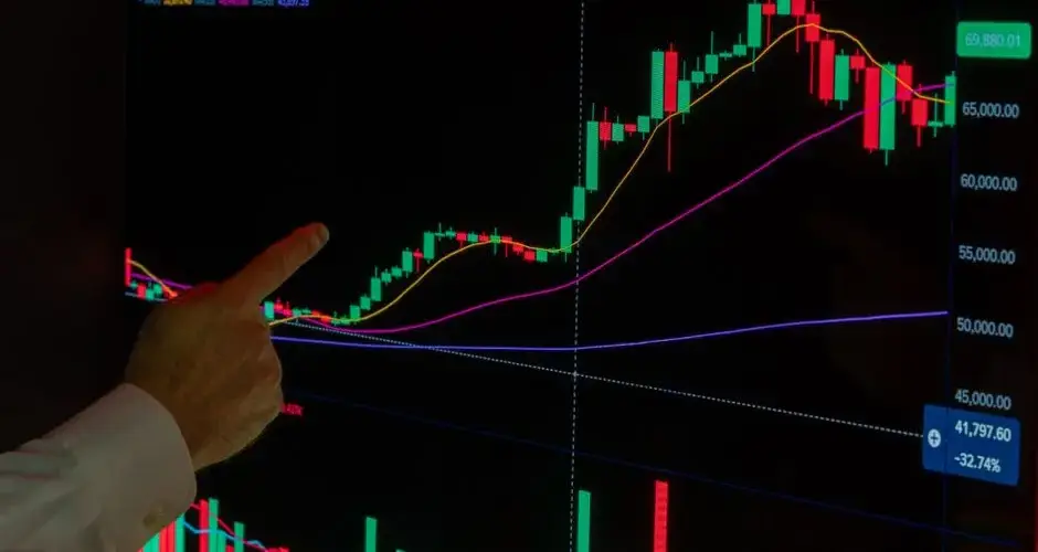 Hand pointing at cryptocurrency chart showing market trends and analysis.