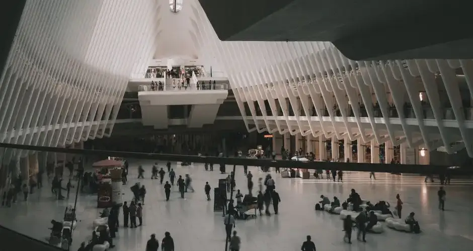 The bustling interior of The Oculus transit hub in New York City with modern architectural design.