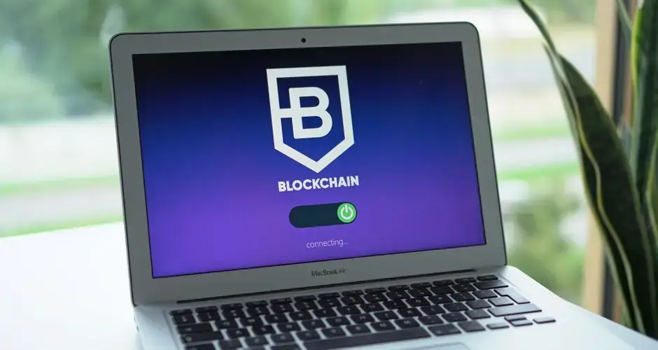 A laptop screen displays a blockchain interface, highlighting digital finance technology.