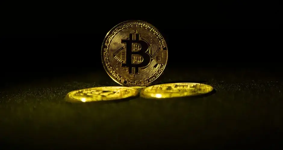 Golden Bitcoin coins symbolizing cryptocurrency wealth on a dark background.