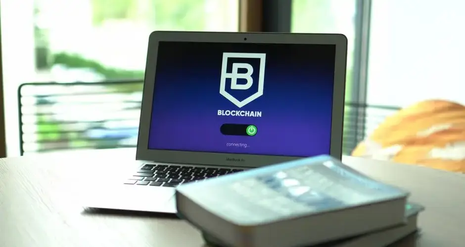 Laptop displaying blockchain connecting screen in modern setting.