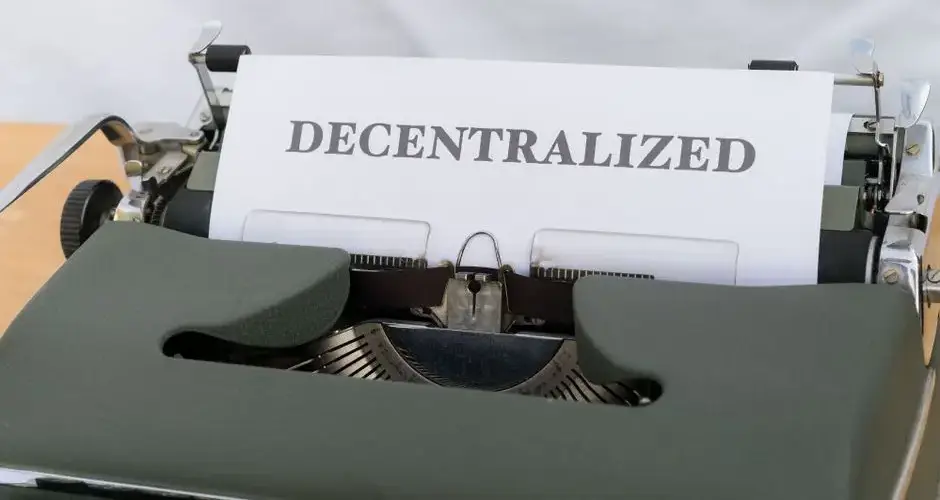 Close-up of a vintage typewriter with paper showing the word 'Decentralized'.