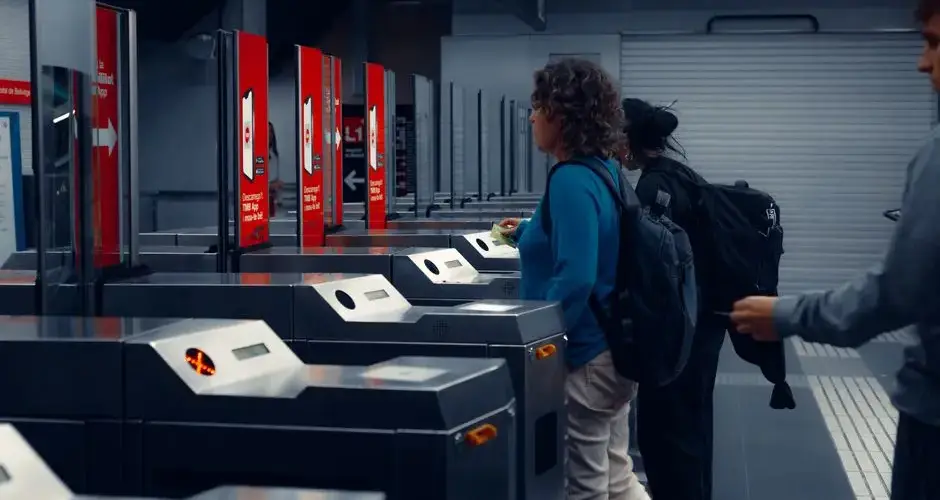 Urban commuters using turnstiles at a modern subway station, showcasing daily public transportation routine.