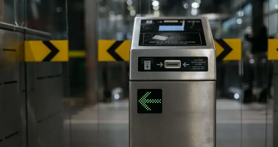 A modern ticket gate with an illuminated arrow for access control in transit systems.