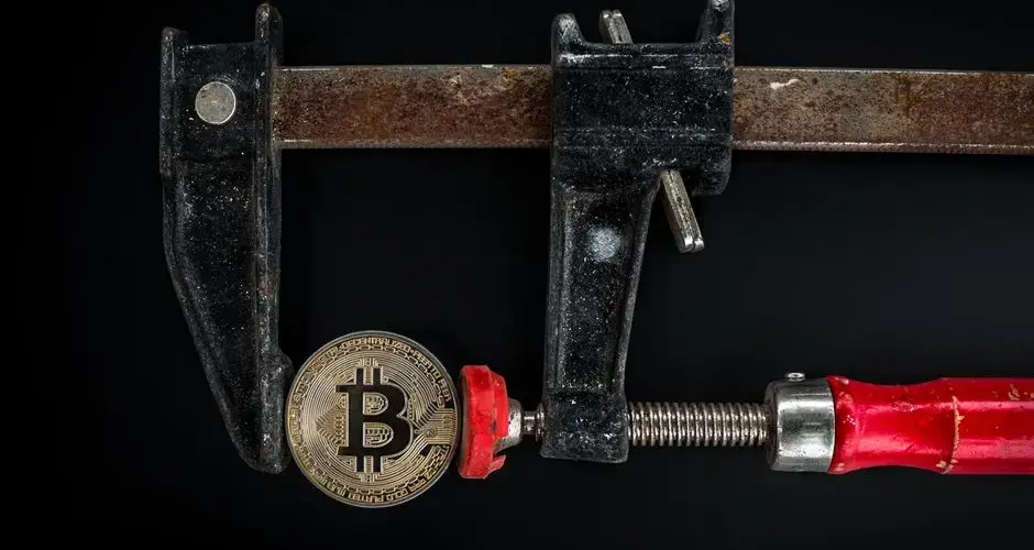 Conceptual image of cryptocurrency represented by a Bitcoin secured in a rusty clamp.