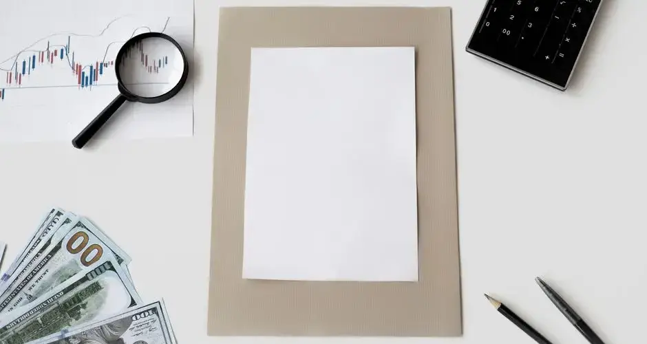 Flat lay of financial tools and blank paper for planning or mockup.