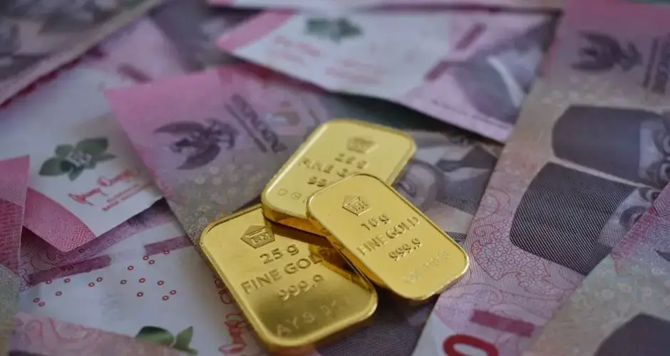 Close-up of gold bars on Thai baht banknotes, symbolizing wealth and prosperity.